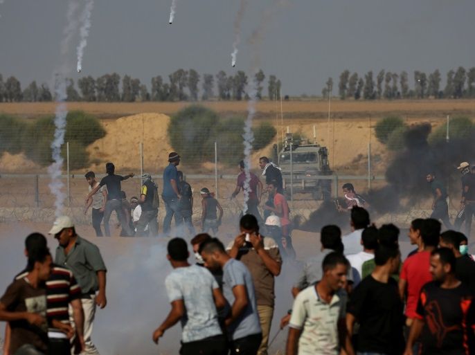 Tear gas canisters are fired by Israeli troops towards Palestinian demonstrators as they run during a protest demanding the right to return to their homeland at the Israel-Gaza border, in the southern Gaza Strip August 17, 2018. REUTERS/Ibraheem Abu Mustafa