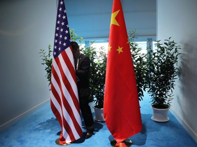 Chinese official prepares the flags for the China-USA bilateral meeting at the G20 leaders summit in Hamburg, Germany July 8, 2017. REUTERS/Carlos Barria