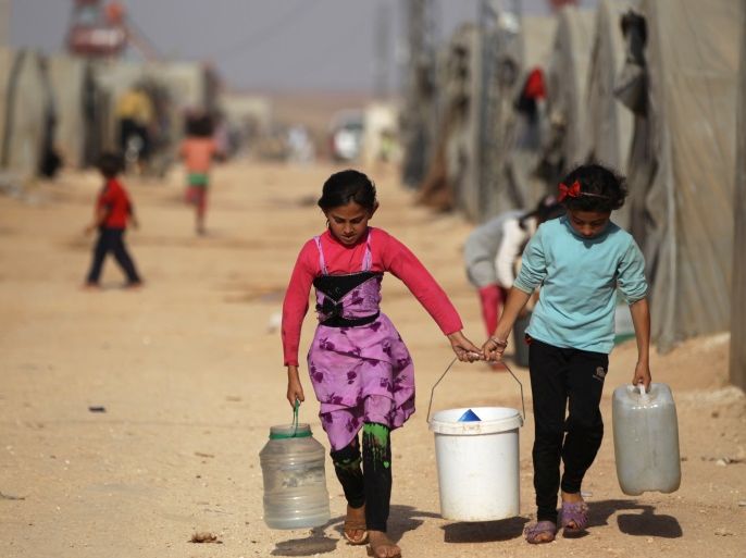 Internally displaced Syrian girls carry water containers in Jrzinaz camp, in the southern part of Idlib, Syria, June 21, 2016. REUTERS/Khalil Ashawi