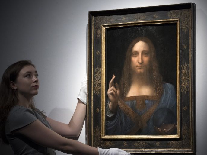 LONDON, ENGLAND - OCTOBER 24: A member of staff poses with a painting by Leonardo da Vinci entitled 'Salvator Mundi' before it is auctioned in New York on November 15, at Christies on October 24, 2017 in London, England. The painting is the last Da Vinci in private hands and is expected to fetch around 100,000,000 USD. (Photo by Carl Court/Getty Images)