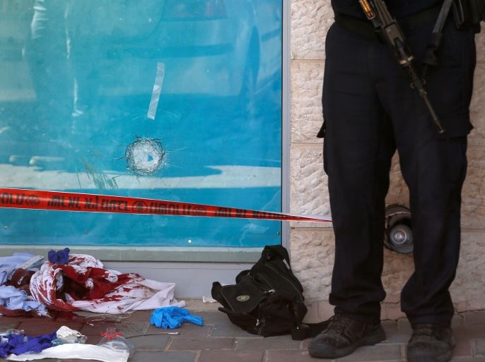 Blood-stained clothes and a bullet hole in a glass panel are seen at the scene of a stabbing attack near a mall in the Gush Etzion Junction in the occupied West Bank, September 16, 2018. REUTERS/Ronen Zvulun