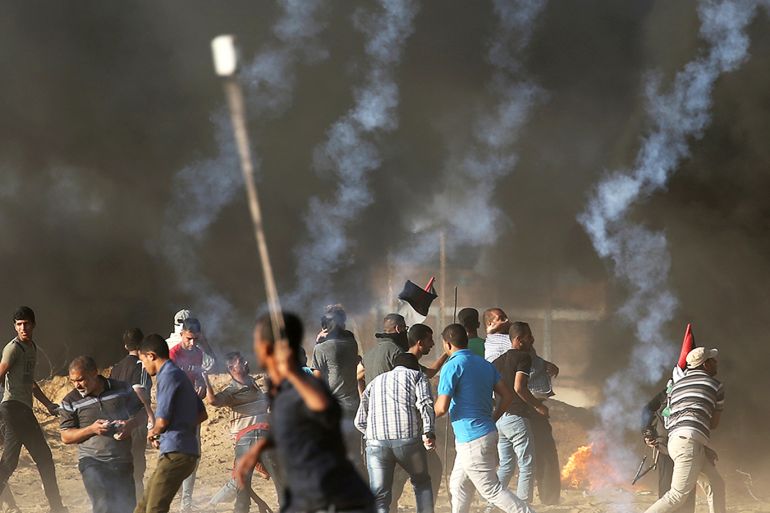 Palestinians hurl stones at Israeli troops during a protest calling for lifting the Israeli blockade on Gaza and demanding the right to return to their homeland, at the Israel-Gaza border fence in the southern Gaza Strip October 12, 2018. REUTERS/Ibraheem Abu Mustafa