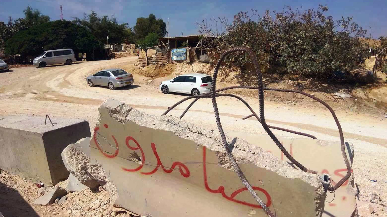  صامدون.. كتبت على مدخل قرية الخان الأحمر المهددة بالهدم الإسرائيلي وترحيل 200 فلسطيني يعيشون فيها منذ ستة عقود (الجزيرة)