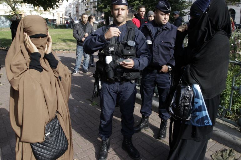 French police and gendarmes check identity cards of two women for wearing full-face veils, or niqab, as they arrived to demonstrate after calls on the internet by Islamic groups to protest over an anti-Islam video, in Lille September 22, 2012. In France, the publication of cartoons denigrating the Prophet Mohammad have stoked anger over an anti-Islam video and the authorities have banned all protests over the issue. It is illegal to wear face-covering headgear in France. REUTERS/Pascal Rossignol (FRANCE - Tags: POLITICS RELIGION CRIME LAW)