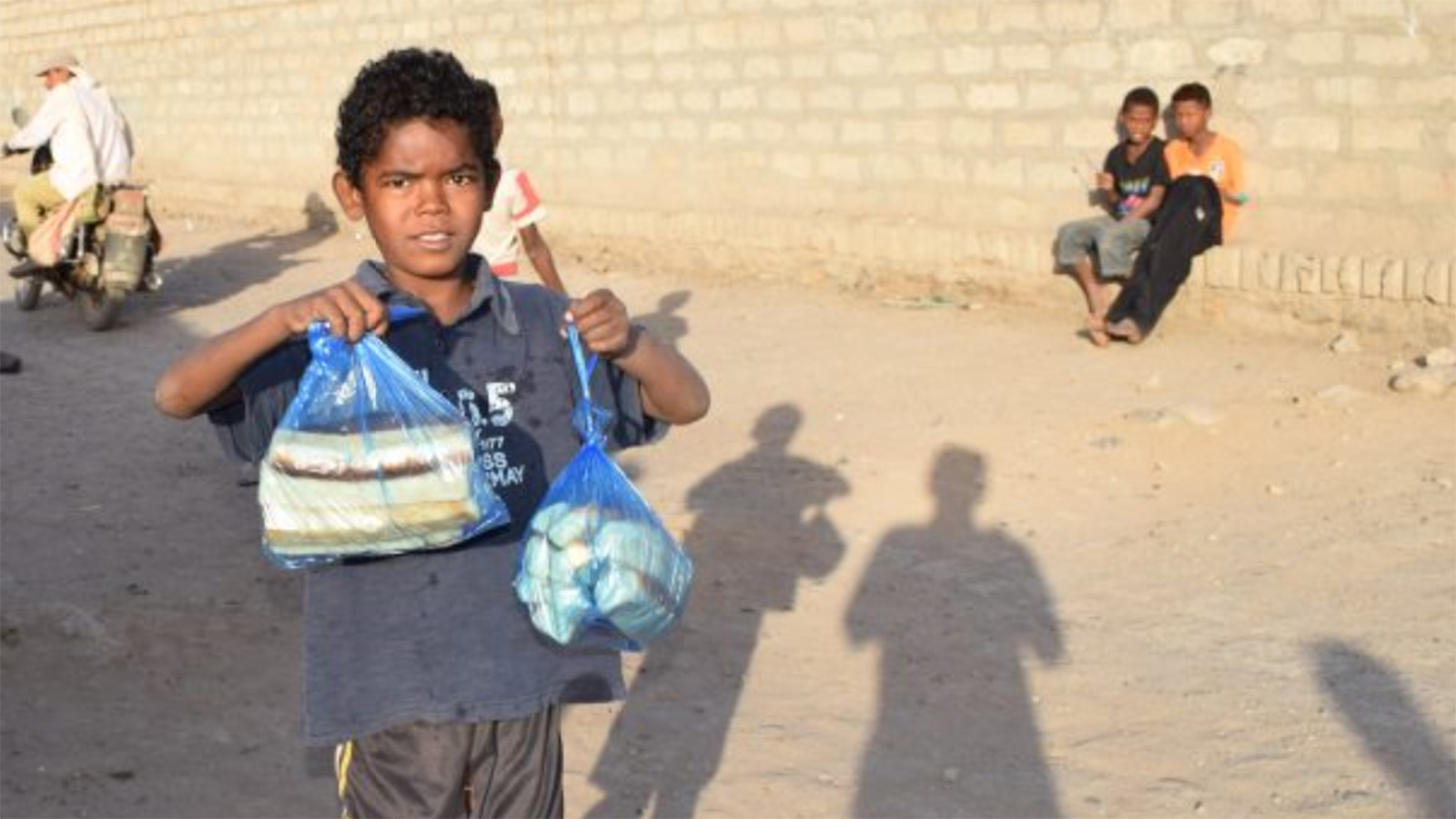 ‪أحد الأطفال اليمنيين بعد حصوله على مساعدات غذائية من إحدى المنظمات‬ (الجزيرة)