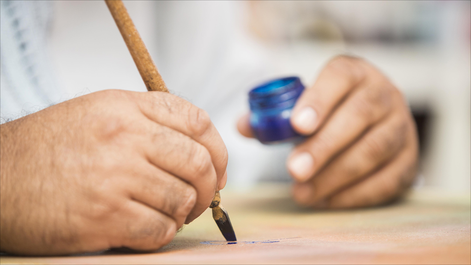 ‪الصانع التقليدي والخطاط عزيز مشاشتي يخط إحدى لوحاته‬ (الجزيرة)