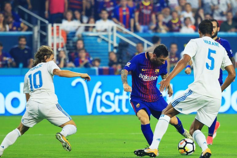 MIAMI GARDENS, FL - JULY 29: Lionel Messi #10 of Barcelona scores against the defense of Raphael Varane #5 and Luka Modric #10 of Real Madrid in the first half during their International Champions Cup 2017 match at Hard Rock Stadium on July 29, 2017 in Miami Gardens, Florida. Chris Trotman/Getty Images/AFP== FOR NEWSPAPERS, INTERNET, TELCOS & TELEVISION USE ONLY ==