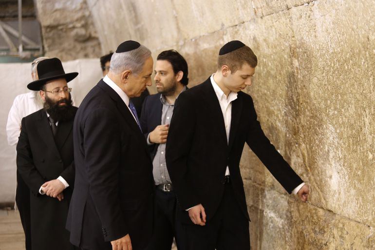 epa04667626 Israeli Prime Minister Benjamin Netanyahu (L) and his son Yair leave a note in the Western Wall as they come to pray at the Jewish holy site in Jerusalem's Old City, Israel, 18 March 2015. Israel's parliamentary elections took a dramatic turn, with Prime Minister Benjamin Netanyahu's Likud party emerging as the big winner, confounding all expectations in the lead-up to the vote. EPA/ABIR SULTAN