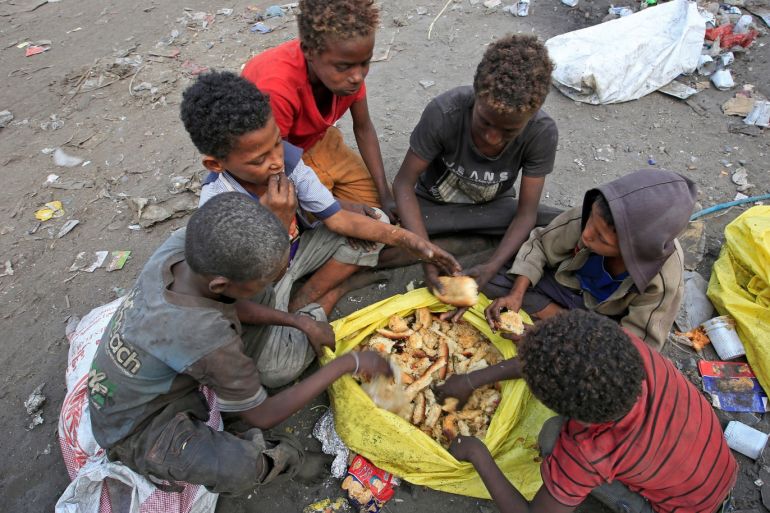 Boys eat bread they collected from a garbage dump on the outskirts of the Red Sea port city of Hodeida, Yemen January 7, 2018. REUTERS/Abduljabbar Zeyad TPX IMAGES OF THE DAY