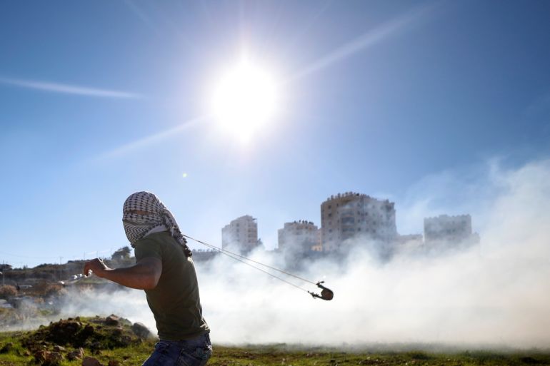 A Palestinian uses a sling to hurl stones during clashes with Israeli troops near the Jewish settlement of Beit El, near Ramallah, in the Israeli-occupied West Bank December 14, 2018. REUTERS/Mohamad Torokman