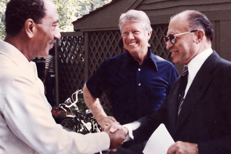 (FILES) File photo dated 06 September 1978 shows Egyptian President Anwar al-Sadat (L) shaking hands with Israeli Premier Menachem Begin (R) as US President Jimmy Carter looks at Camp David, the US presidential retreat in Maryland. Israel and Egypt went on 26 March, 1979 to sign a historic US-sponsored peace accord, which is still in effect today. Jimmy Carter won the 2002 Nobel Peace Prize 11 October, 2002. Carter's Nobel Peace Prize award coincides with the 20th anniversary of the non-profit-making Carter Center, which bears his name. Under the slogan "Waging Peace, Fighting Disease, Building Hope", the Atlanta-based center has diligently carried out missions around the globe, concentrating on human rights and democracy, resolving conflicts as well as getting involved in health-oriented aid projects. EPA PHOTO/WHITE HOUSE