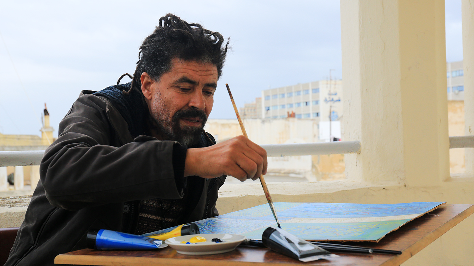 ‪الفنان منجي الفرحاني يرسم في سطح مرسمه‬ (الجزيرة)