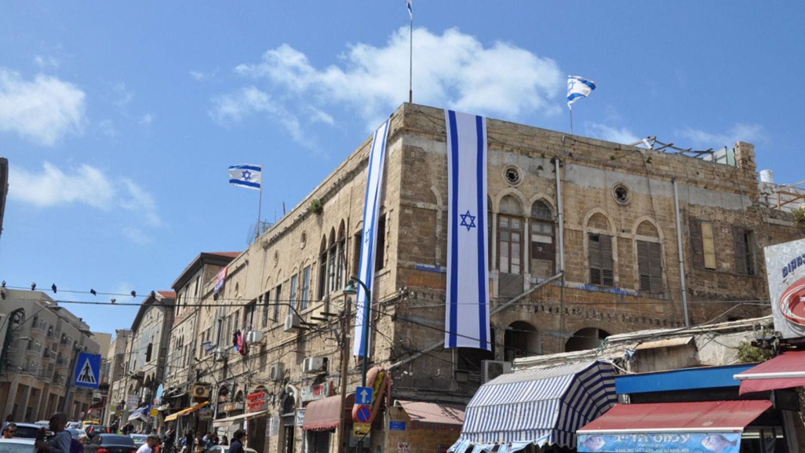 ‪الأعلام الإسرائيلية وضعت على عقارات للاجئين الفلسطينيين بيعت بالمزاد العلني لشركات يهودية‬ (الجزيرة)