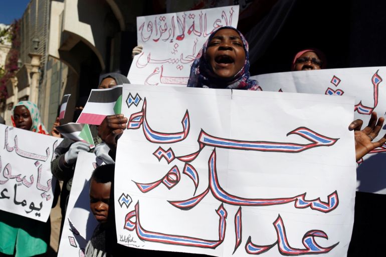 Sudanese protesters shout slogans against Sudan's President Omar al-Bashir as they demonstrate outside the closed Sudanese embassy in Sanaa, Yemen January 13, 2019. The placard at right reads: