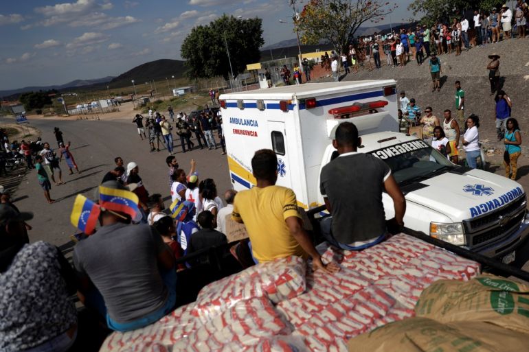 An ambulance carrying wounded people from Venezuela, passes next to a truck with humanitarian aid at the border between Venezuela and Brazil in Pacaraima, Brazil February 23, 2019. REUTERS/Ricardo Moraes