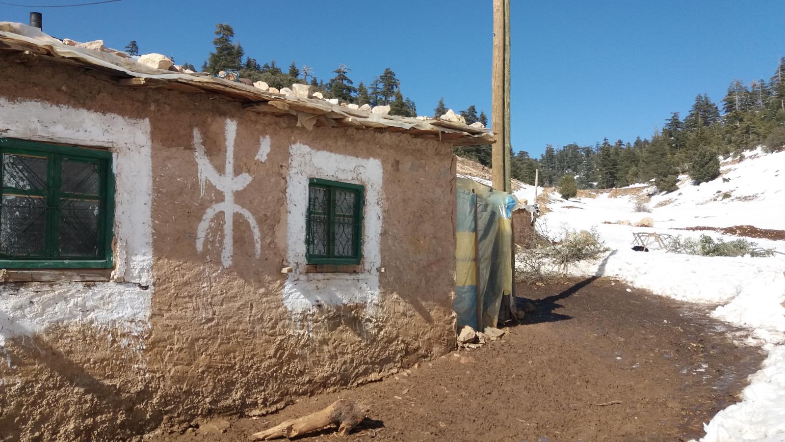 ‪منزل في قرية أمازيغية بجبال الأطلس ويظهر على الحائط أحد حروف 