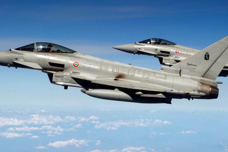 ميدان - Two Italian Typhoon fighter planes demonstrate the interception of a Belgian air force transport plane as they fly over Italy, September 12, 2018, as part of NATO drills. REUTERS/Francois Lenoir