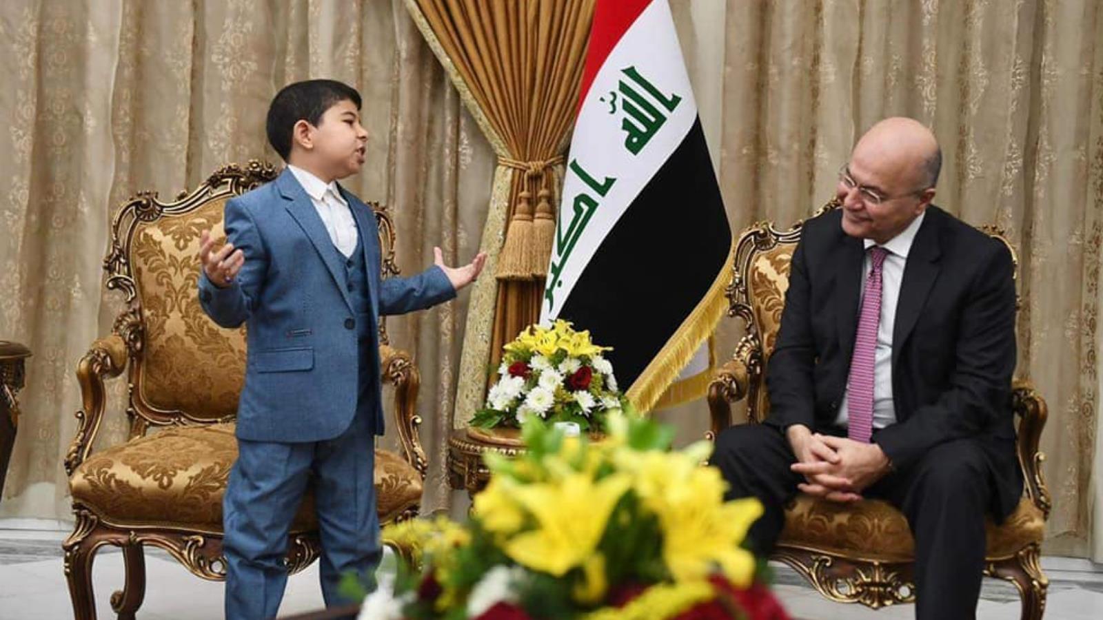 الجواهري الصغير أثناء إلقائه قصيدة أمام الرئيس العراقي برهم صالح