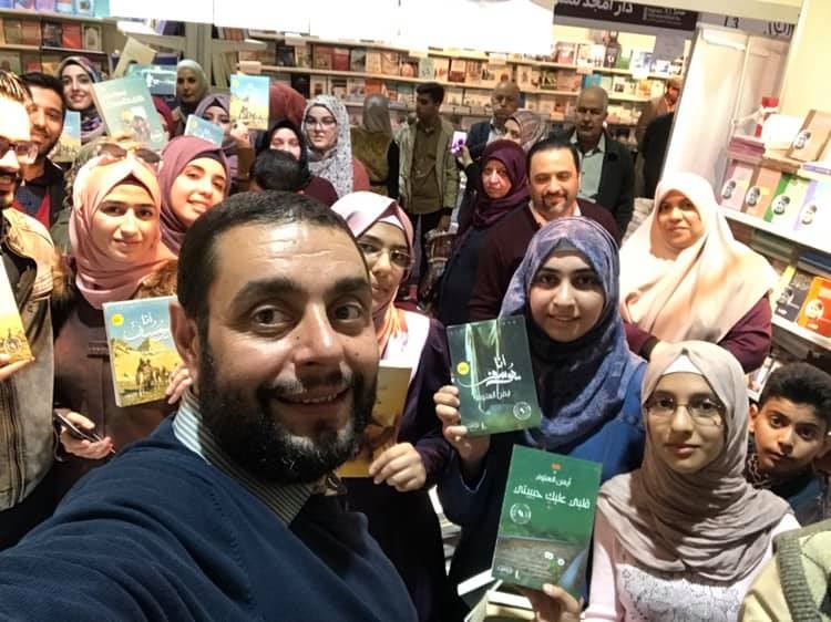 الروائي أيمن العتوم مع بعض جمهوره في معرض بغداد للكتاب 2019 (مواقع التواصل)