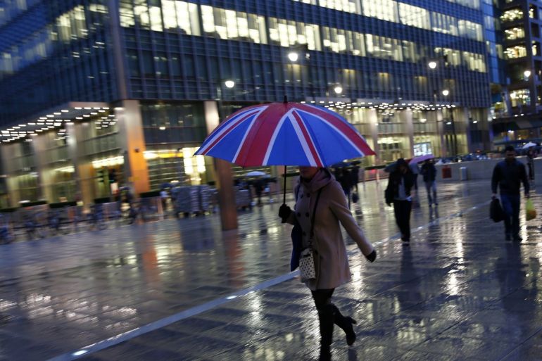 Workers walk in the rain at the Canary Wharf business district in London November 11, 2013. London's financial services sector created 25 percent more jobs in February than a year ago, new data has shown, indicating the industry may be recovering from the restructuring and redundancies prompted by the financial crisis. After a strong January, the City hiring market showed no signs of slowing down last month, with 3,220 new jobs created, compared with 2,575 added in February 2013, according to financial services recruiter Astbury Marsden. The data suggests London's banks and financial services companies are returning to growth after slashing thousands of jobs in the face of a lengthy recession and a series of industry scandals that followed the financial crisis. Picture taken November 11, 2013. REUTERS/Eddie Keogh (BRITAIN - Tags: BUSINESS EMPLOYMENT)ATTENTION EDITORS: PICTURE 23 OF 25 FOR PACKAGE 'CITY OF LONDON - LIFE IN THE SQUARE MILE'. TO FIND ALL IMAGES SEARCH 'RECRUITER KEOGH'