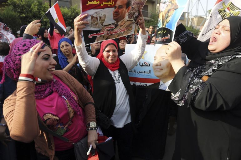 Egyptian female citizens dance in front of the polling stations while carrying Sisi posters in celebration of the election process in Cairo May 26, 2014. Egyptians voted on Monday in a presidential election expected to sweep former army chief Abdel Fatah al-Sisi into office, with supporters brushing aside concerns about human rights and hailing him as the strong leader the country needs. REUTERS/Mohamed Abd El Ghany (EGYPT - Tags: POLITICS ELECTIONS)