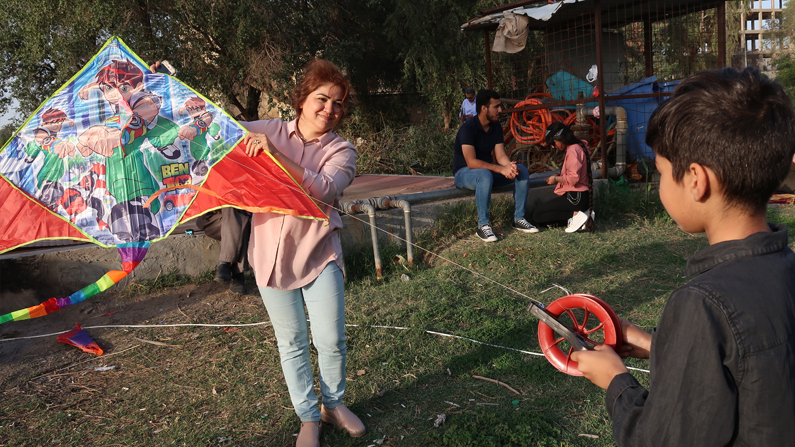 ‪‬ أم عراقية تشارك ابنها في اللعب بالطائرات الورقية(الجزيرة)