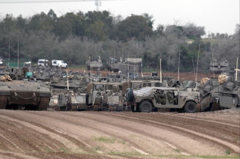 epa07470942 Israeli stand near their Merkava tanks at a gathering point next to the Israeli border with Gaza, 29 March 2019. High tensions prevail on the Gaza border between Israel and Hamas before the anniversary of the Great March of Return. EPA-EFE/ATEF SAFADI