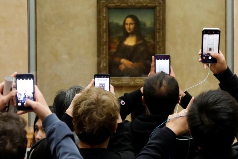 Visitors take pictures of the painting "Mona Lisa" (La Joconde) by Leonardo Da Vinci at the Louvre museum in Paris, France, December 3, 2018. Picture taken December 3, 2018. REUTERS/Charles Platiau
