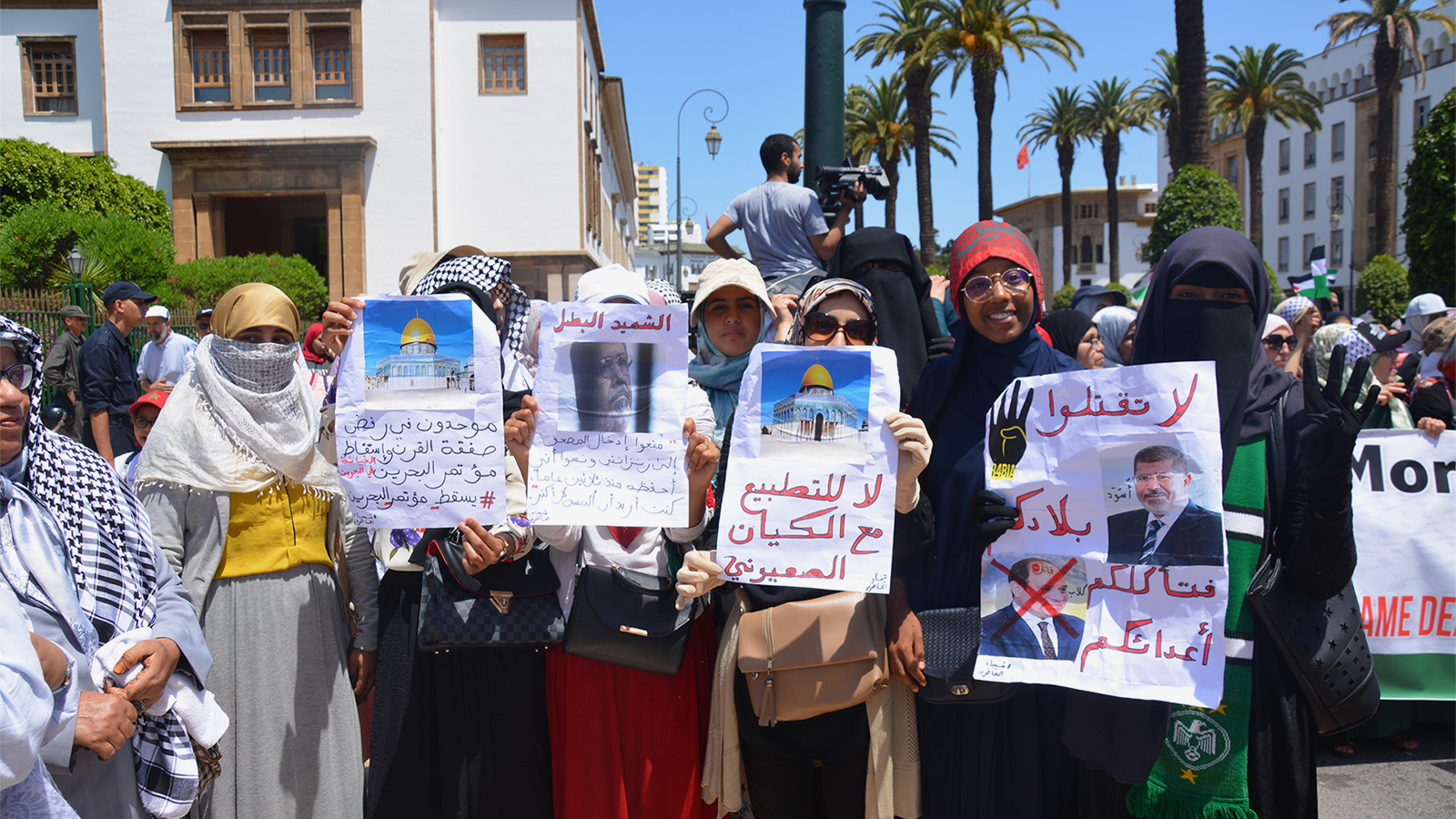‪متظاهرات مغربيات يحملن صورة الرئيس الراحل مرسي وبعض الجمل المأثورة عنه‬ (الجزيرة)