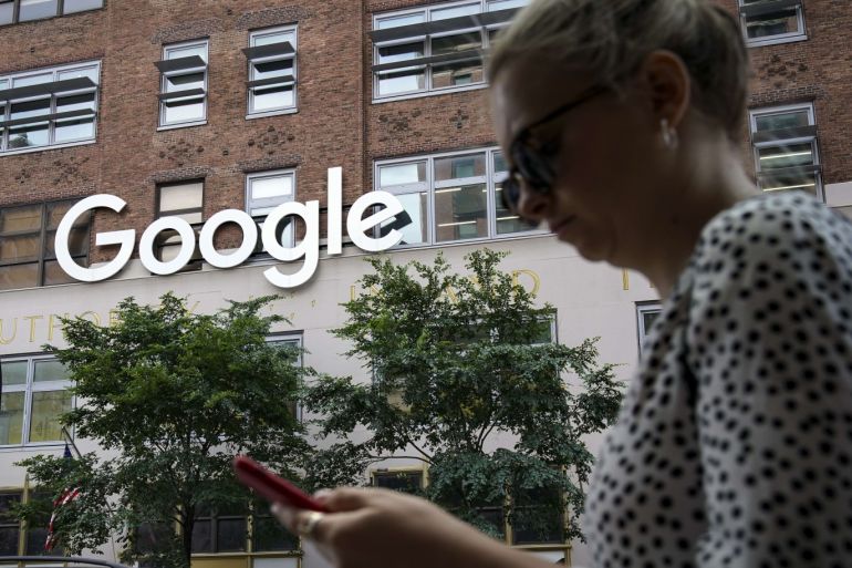 NEW YORK, NY - JUNE 3: A woman looks at her smartphone as she walks past Google Building 8510 at 85 10th Ave on June 3, 2019 in New York City. Shares of Google parent company Alphabet were down over six percent on Monday, following news reports that the U.S. Department of Justice is preparing to launch an anti-trust investigation aimed at Google. Drew Angerer/Getty Images/AFP== FOR NEWSPAPERS, INTERNET, TELCOS & TELEVISION USE ONLY ==