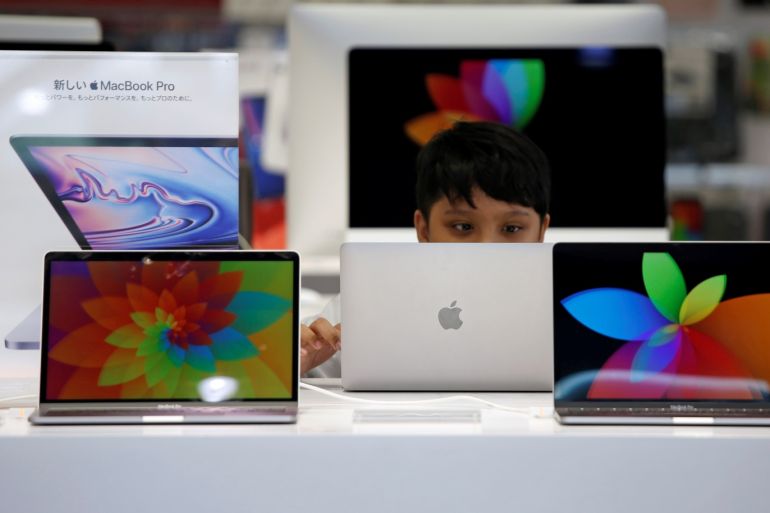 A boy tries to use an Apple laptop at a computer shop in Tokyo, Japan, May 10, 2019. REUTERS/Issei Kato