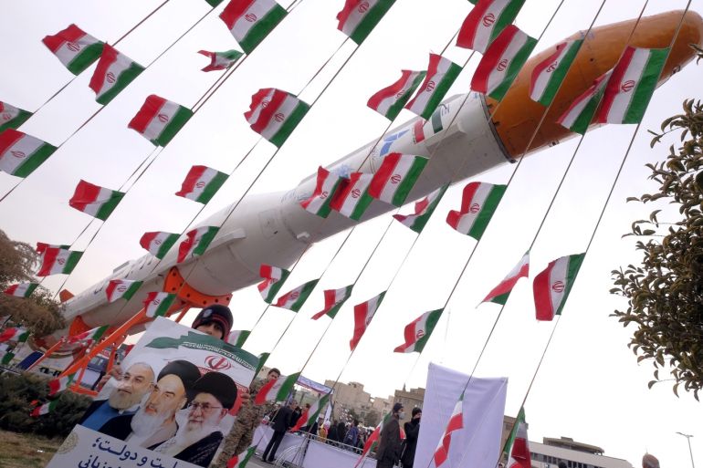 A boy holding a placard with pictures of (L-R) President Hassan Rouhani, the late founder of the Islamic Revolution Ayatollah Ruhollah Khomeini, and Iran's Supreme Leader Ayatollah Ali Khamenei, poses for camera in front of a model of Simorgh satellite-carrier rocket during a ceremony marking the 37th anniversary of the Islamic Revolution, in Tehran February 11, 2016. REUTERS/Raheb Homavandi/TIMAATTENTION EDITORS - THIS IMAGE WAS PROVIDED BY A THIRD PARTY. FOR EDITORIA