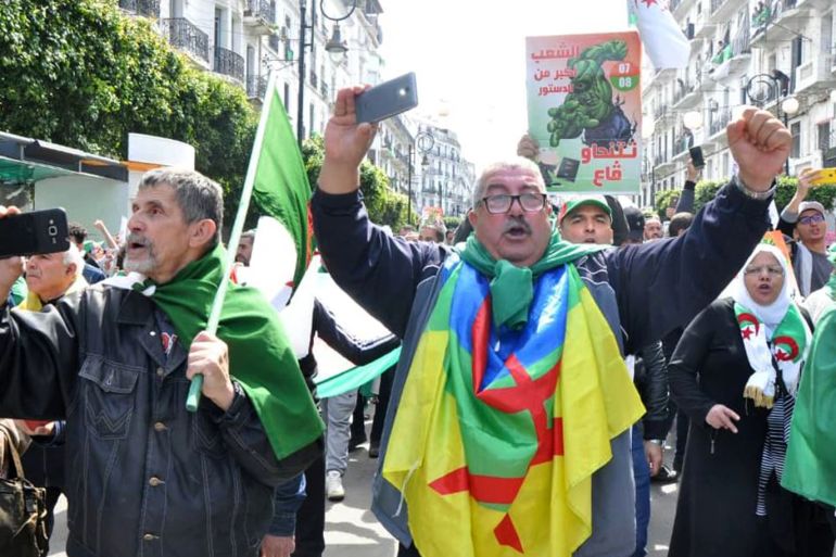 متظاهر يلتحف الراية الأمازيغية في مسيرات العاصمة الجزائرية (الجزيرة)