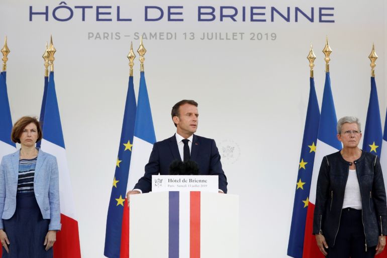 French President Emmanuel Macron is flanked by French Defense Minister Florence Parly and Junior Defense Minister Genevieve Darrieussecq, as he speaks at the residence of French Defense Minister on the eve of Bastille Day in Paris, France, July 13, 2019. Kamil Zihnioglu/Pool via REUTERS