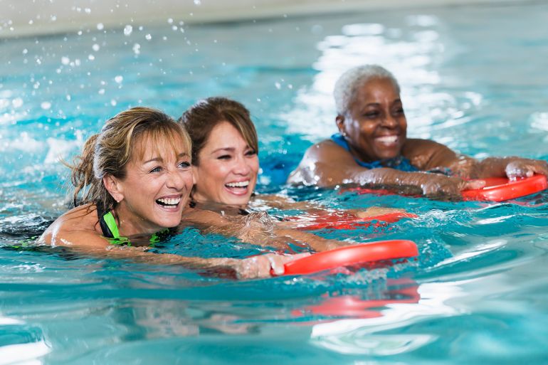 Multiracial middle-aged women swimming in pool