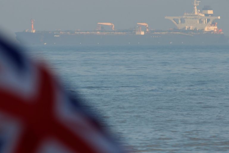 The British Union Jack flag flies in front of Iranian oil tanker Grace 1 as it sits anchored after it was seized in July by British Royal Marines off the coast of the British Mediterranean territory on suspicion of violating sanctions against Syria, in the Strait of Gibraltar, southern Spain August 14, 2019. REUTERS/Jon Nazca