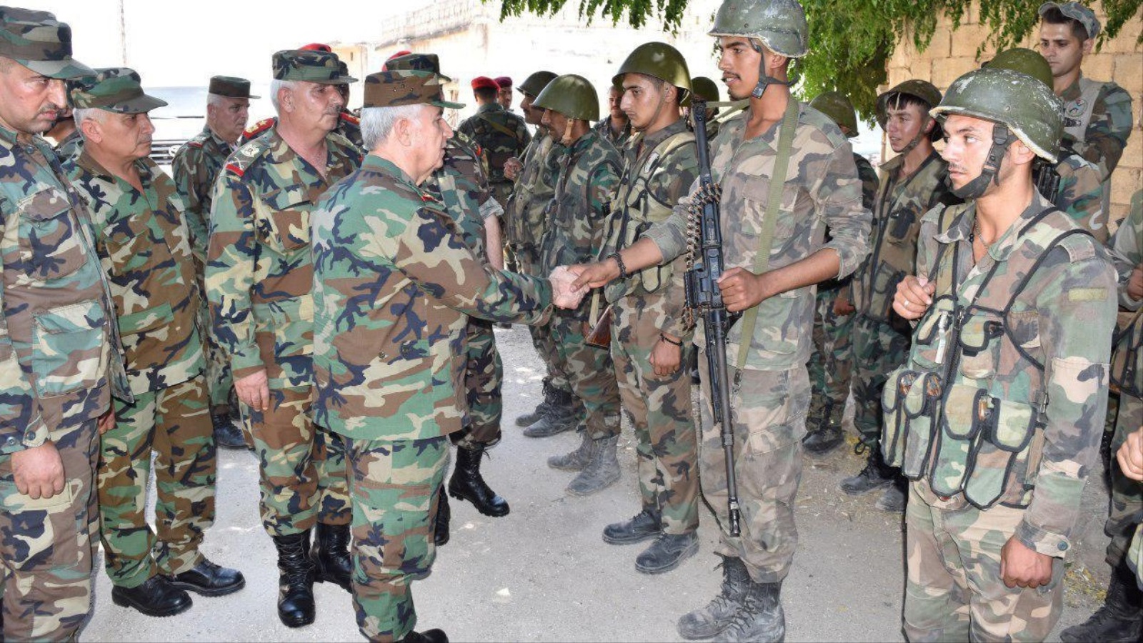 ‪وزير الدفاع السوري يسلم على جنود النظام بمدينة الهبيط بعد السيطرة عليها أمس‬ (رويترز)