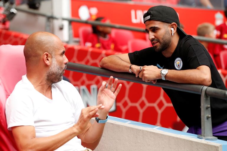 Soccer Football - FA Community Shield - Manchester City v Liverpool - Wembley Stadium, London, Britain - August 4, 2019 Manchester City manager Pep Guardiola speaks with Riyad Mahrez before the match Action Images via Reuters/John Sibley