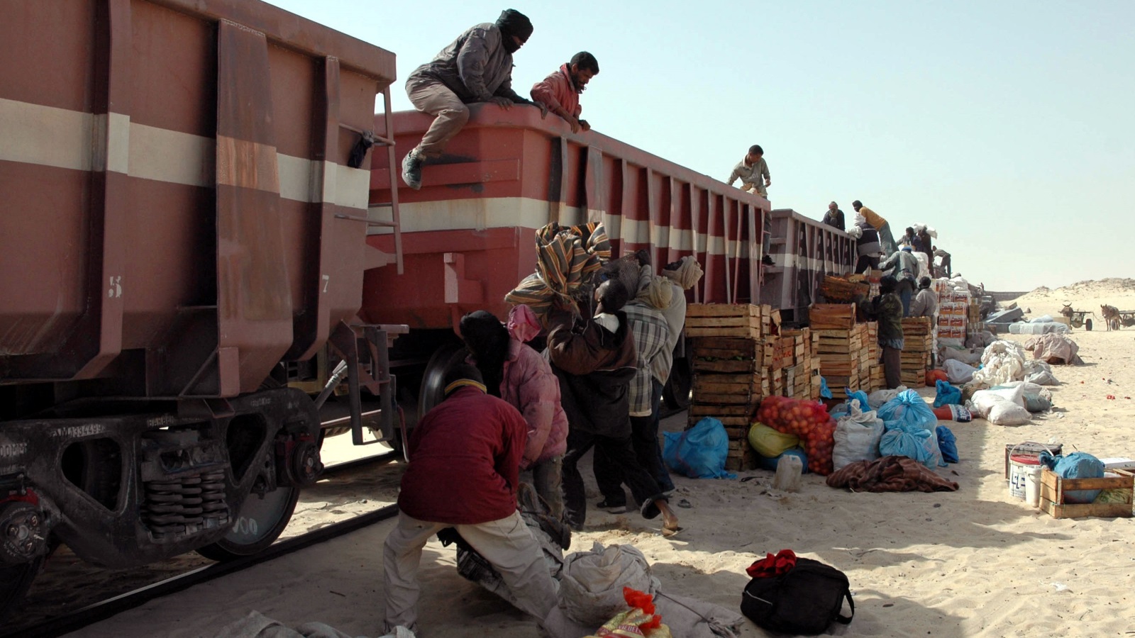 سكان الزويرات يركبون فوق عربات قطار نقل خامات الحديد لنقل أغراضهم بطريقة غير قانونية (رويترز)