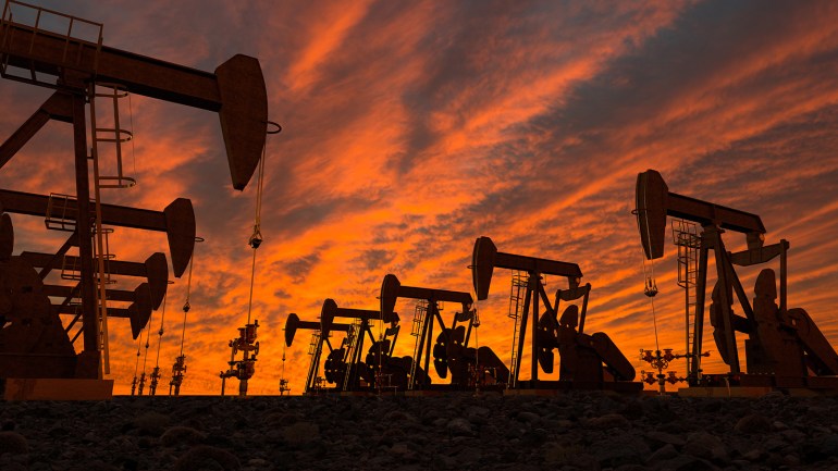 Silhouette Oil Pumps On Field Against Cloudy Sky During Sunset