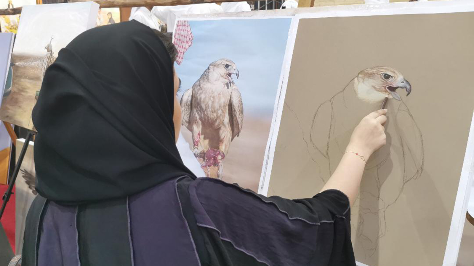 مشاركة فنانين من قطر في تجميل المعرض بلوحات عن الصقور(الجزيرة نت)