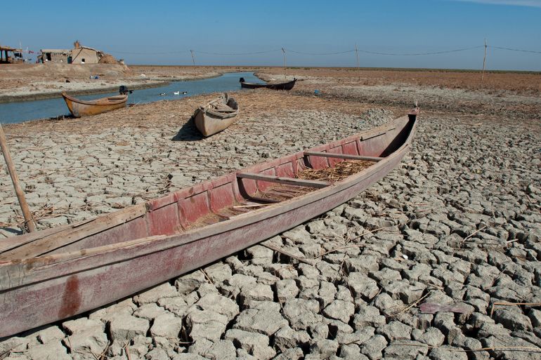 AL-CHIBAYISH, MARSHES OF SOUTHERN IRAQ, IRAQ - 2018/11/01: A traditional Marsh Arab boat seen laying idle on dry and cracked Marsh in the Central Marshes of Southern Iraq. Climate change, dam building in Turkey and internal water mismanagement are the main causes of a severe drought in the southern wetlands of Iraq. (Photo by John Wreford/SOPA Images/LightRocket via Getty Images)