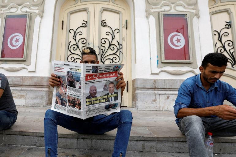 A man reads a local newspaper displaying pictures of two candidates for the second round of Tunisia's presidential election, in Tunis, Tunisia September 18, 2019. REUTERS/Zoubeir Souissi