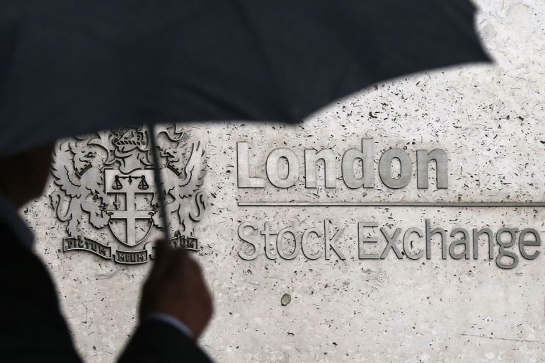 A man shelters under an umbrella as he walks past the London Stock Exchange in London, Britain August 24, 2015. World stock markets plunged on Monday, as a near 9-percent dive in China shares and a sharp drop in the dollar and major commodities sent investors rushing for the exit. The Dow Jones Industrial Average dropped more than 1,000 points as Wall Street opened, and the benchmark Standard & Poor's 500 index slid more than 2.5 percent, a drop that puts it nearly 10 percent below its record high. REUTERS/Suzanne Plunkett