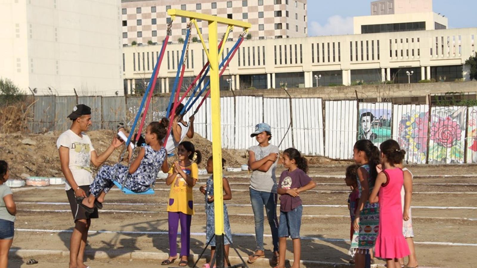 أطفال جزائريون يلعبون في فضاء ترفيهي بحي الحامة بعد تهيئته (الجزيرة)