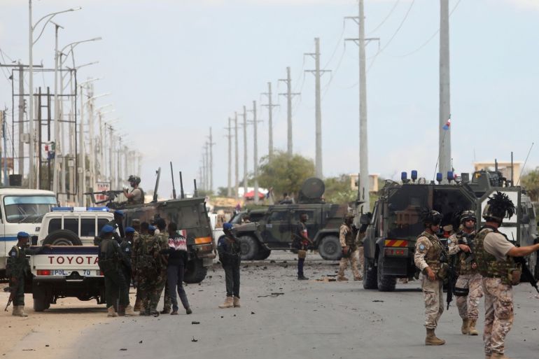 Italian and Somali security forces are seen near armoured vehicles at the scene of an attack on an Italian military convoy in Mogadishu, Somalia September 30, 2019. REUTERS/Feisal Omar