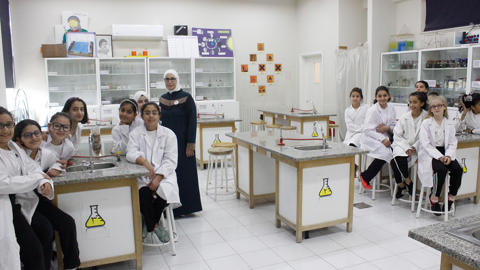طالبات ومعلمتهن في مختبر العلوم بأحد المدارس الخاصة شمال العاصمة عمان (الجزيرة-أرشيف)
