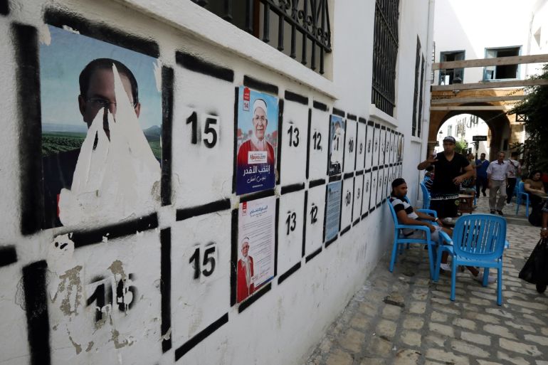 People walk past election campaign posters of presidential candidates in Tunis, Tunisia, September 13, 2019. REUTERS/Muhammad Hamed