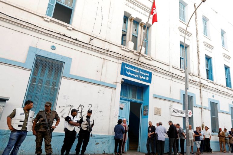 Members of security forces stand guard as people wait to cast their votes outside a polling station during parliamentary elections, in Tunis, Tunisia October 6, 2019. REUTERS/Zoubeir Souissi