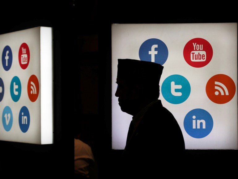 A delegate of the 41st annual meeting of the Islamic Development Bank (IDB) walks in front of social media logos at the Jakarta Convention Center in Jakarta, Indonesia, May 16, 2016. REUTERS/Beawiharta TPX IMAGES OF THE DAY